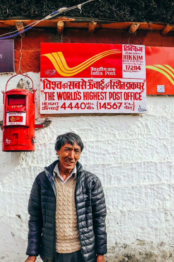 A man stands in front of the world's highest post office in Hikkim, India.
